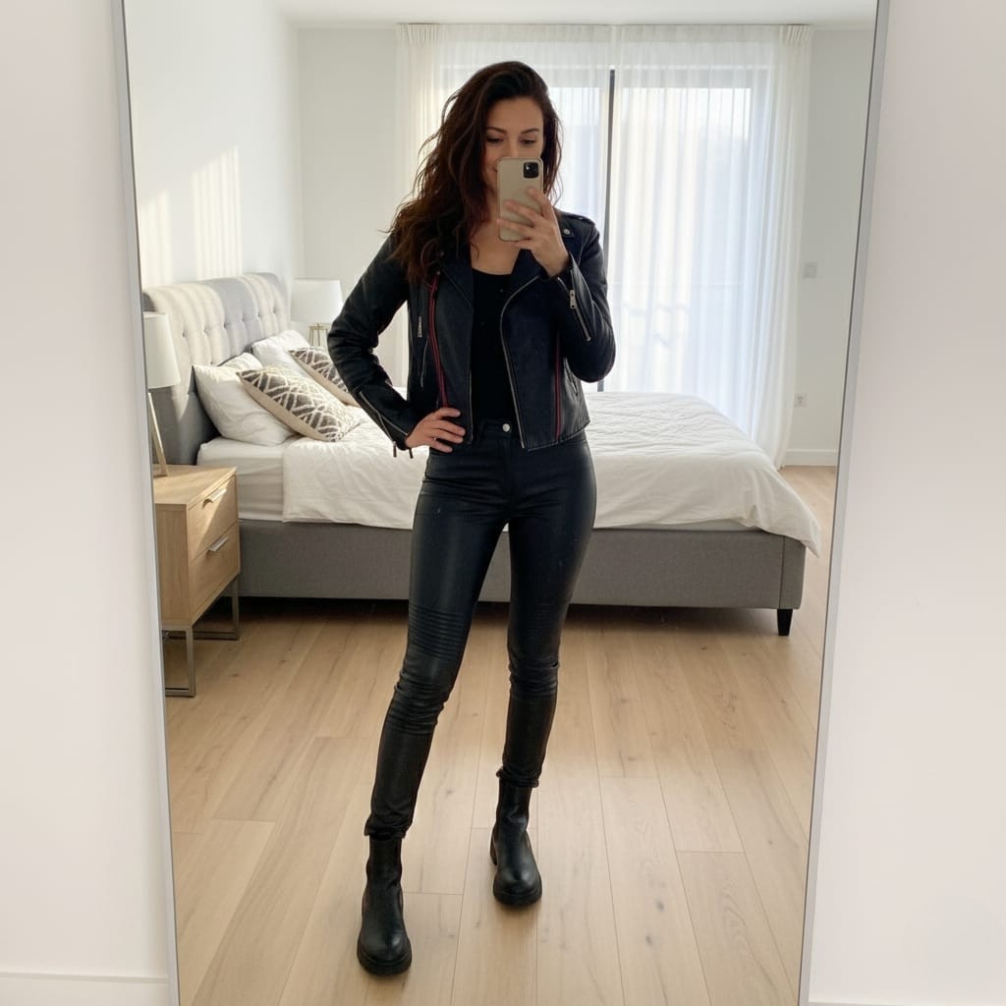 A woman in a stylish black leather jacket and matching trousers.
